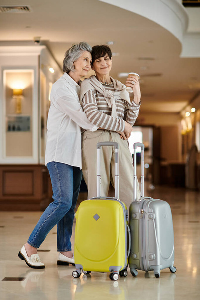 Senior couple lesbien prêt pour l'aventure avec bagages à la main. - Photo, image