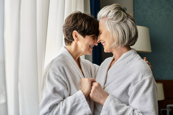 Zarte ältere lesbische Paare stehen zusammen in einem Hotel. - Foto, Bild