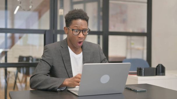 Afroamerykanin wstrząśnięty stratą na laptopie - Zdjęcie, obraz