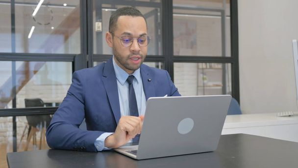 Uomo in giacca e cravatta che fa video chat via computer portatile - Foto, immagini