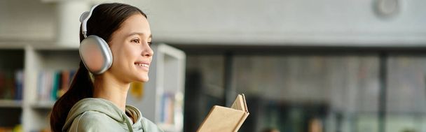 Ein Mädchen mit Kopfhörern in einem Buch, das Lesen und Musik für ein harmonisches Lernerlebnis kombiniert. - Foto, Bild