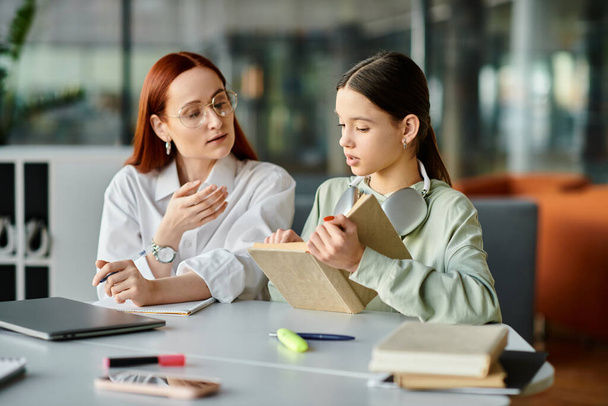 Eine rothaarige Frau unterrichtet ein Teenager-Mädchen an einem Tisch, das nach der Schule im Unterricht beschäftigt ist. - Foto, Bild