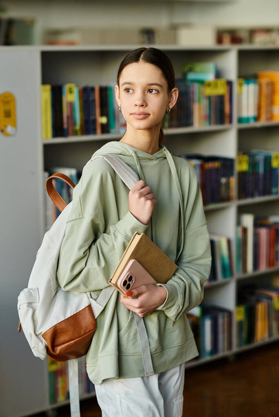 teini-ikäinen tyttö, jolla on reppu kirjastossa, koulun jälkeinen koulutus. - Valokuva, kuva