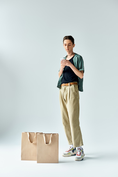 Una mujer con estilo con bolsas de compras golpea una pose sobre un fondo blanco liso. - Foto, imagen