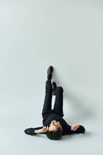 A young queer person peacefully lays on his back on a white background. - Photo, Image