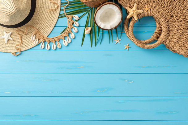 Вид сверху основных аксессуаров для летнего отдыха на ярко синем деревянном фоне. Включает в себя шляпу, кокос, соломенный мешок, и раковины моря - Фото, изображение