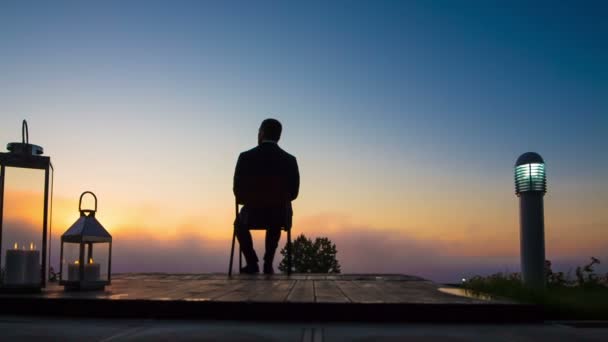 üzleti ember néz napkelte-teraszon - Felvétel, videó