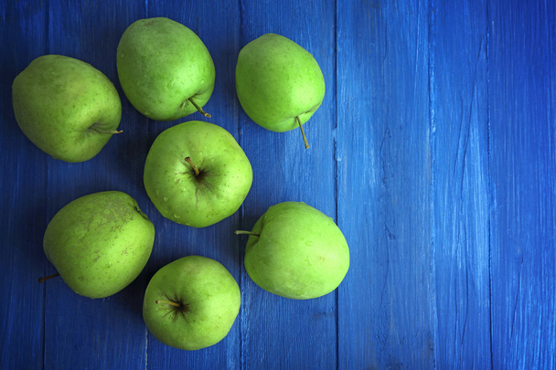 Green apples on color wooden background - Fotoğraf, Görsel