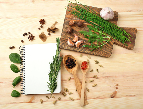 Open recipe book with fresh herbs and spices on wooden background - Foto, Bild