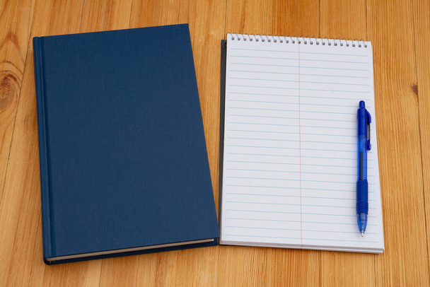 Okulda not almak için not defteri ve kalem yıpranmış masası olan eski mavi bir kitap.  - Fotoğraf, Görsel