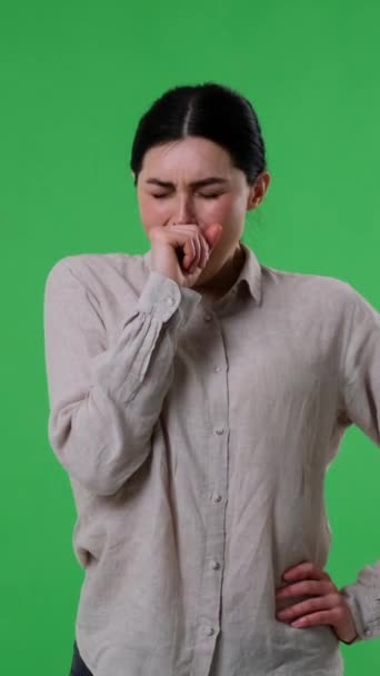Exhausted or bored Caucasian woman stretching and yawning on green background. Laziness, boredom or tiredness concept. Vertical video. - Footage, Video