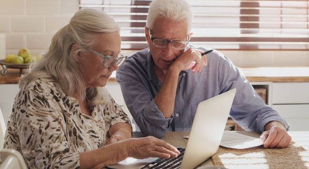 Пожилая пара, ноутбук и кухня для исследований, финансовый бюджет и онлайн инвестиции для оплаты ипотеки в пенсии. Мужчина, женщина и серьезные с технологией для планирования стратегии интернет-банкинга. - Фото, изображение