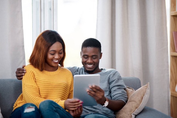 Black couple, tablet and couch with digital app in home for streaming entertainment, movie or internet. Man, woman and relax in apartment with network subscription for watching, bonding or website. - Photo, Image