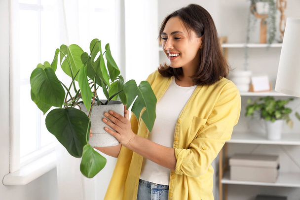 Fiatal nő növényekkel otthon - Fotó, kép