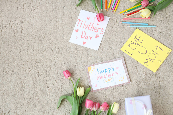 Äitienpäivän tulppaanit, kynät ja onnittelukortit lattialla - Valokuva, kuva