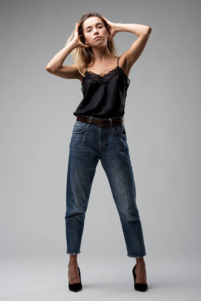 Roupa casual mas refinada da mulher, completa com um top de renda preta e jeans, retrata moda casual moderna - Foto, Imagem