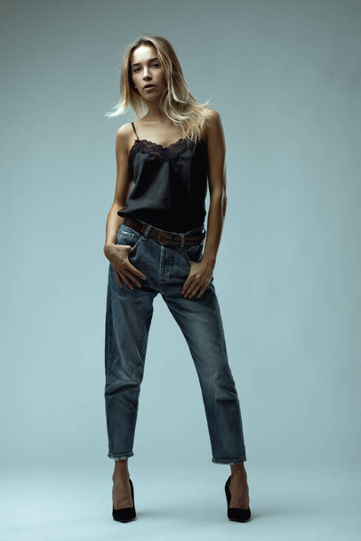 Портрет всего тела отражает смесь тонкого кружева и прочной джинсы, подчеркнутой шипованной лентой и уверенной позицией - Фото, изображение