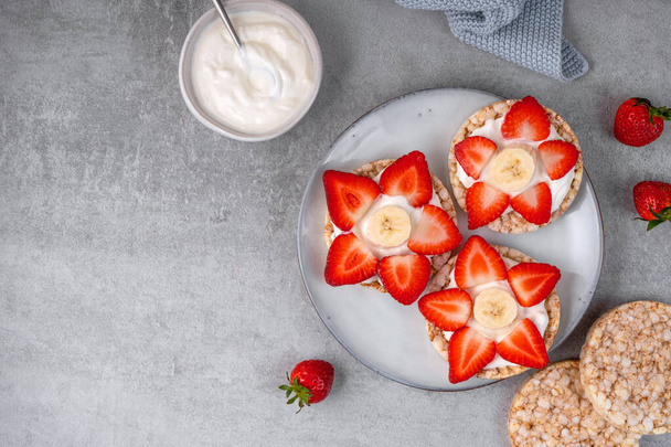 Rizs keksz egészséges snack, keksz tetején eper és banán, Virág alakú reggeli ötlet - Fotó, kép