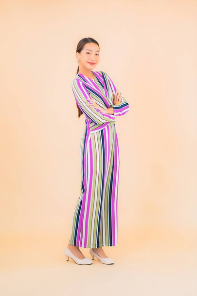 Portrait belle jeune femme asiatique sourire se détendre en action sur fond de couleur - Photo, image