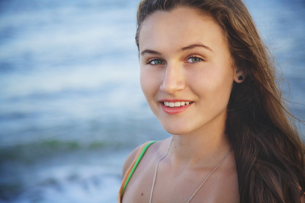 Портрет молодой красивой девушки на пляже на закате
 - Фото, изображение