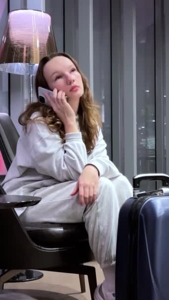 Nő, telefon és késleltetés a repülőtéren, miközben kimerült, dühös és fáradt a várakozástól. Utazási poggyász, késő és ideges ázsiai személy stressz egy okostelefon és nézni, hogy ellenőrizze. Beszállás ütemezése - Felvétel, videó