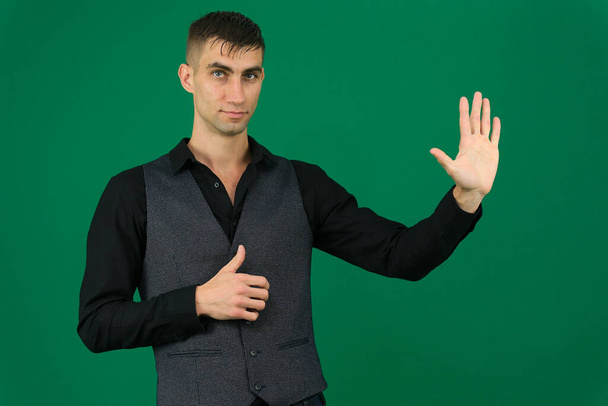 emotions of a handsome man guy on a green background chromakey close-up dark hair young man. spy - Photo, Image