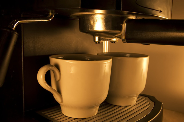 Coffee maker pouring hot espresso coffee in two cups. Take your break! - Фото, изображение