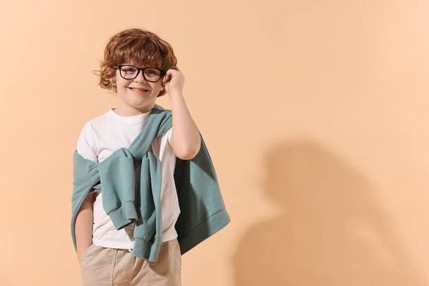 Koncepcja mody. Stylowy chłopak na jasnopomarańczowym tle. Miejsce na tekst - Zdjęcie, obraz