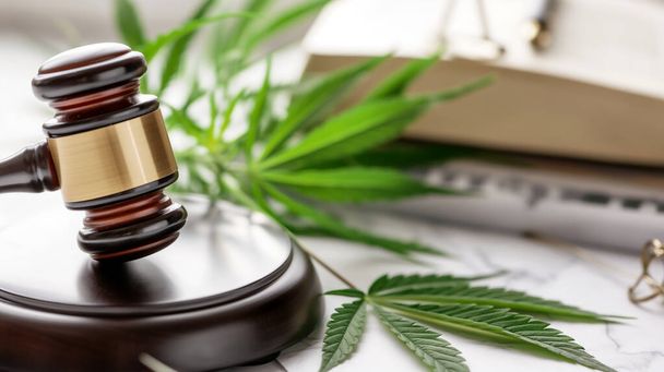 Gavel légal et feuille de cannabis, symbolisant la loi, la légalisation et les questions de réglementation. - Photo, image