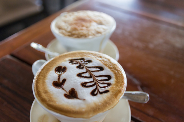 een kopje cappuccino koffie met hart-vorm latte art - Foto, afbeelding