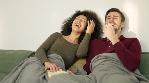 Hidasliikkeinen video monirotuinen pari nauraa katsellessaan hauskaa elokuvaa kotona - Materiaali, video