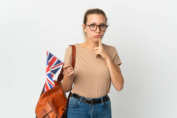 白い背景と思考で孤立したイギリスの国旗を保持している若い金髪の女性 - 写真・画像