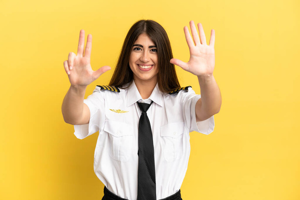 Pilote d'avion isolé sur fond jaune comptant huit doigts - Photo, image