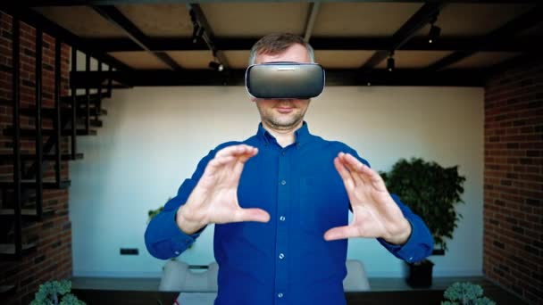 Человек жестикулирует, используя гарнитуру виртуальной реальности в офисе - Кадры, видео