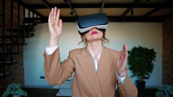 Nainen elehtii käyttäessään Virtual Reality kuulokkeet toimistossa - Materiaali, video