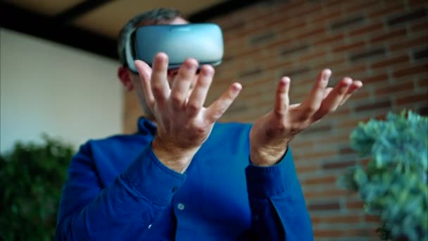 Muž gestikuluje při použití sluchátek virtuální reality v kanceláři - Záběry, video