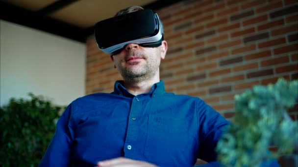 Man gebaren tijdens het gebruik van een Virtual Reality headset in een kantoor - Video