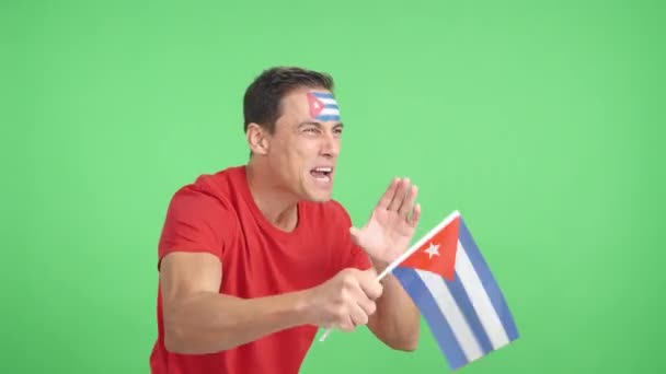 Stüdyoda, Küba 'ya tezahürat yapan, ulusal bir bayrak sallayan ve boş bir şekilde fotokopi odasına bakan bir adamın kromasıyla. - Video, Çekim