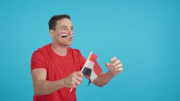 Video in studio con croma di un uomo che guarda altrove sventolando una bandiera nazionale egiziana, arrabbiato con un con una decisione arbitri - Filmati, video