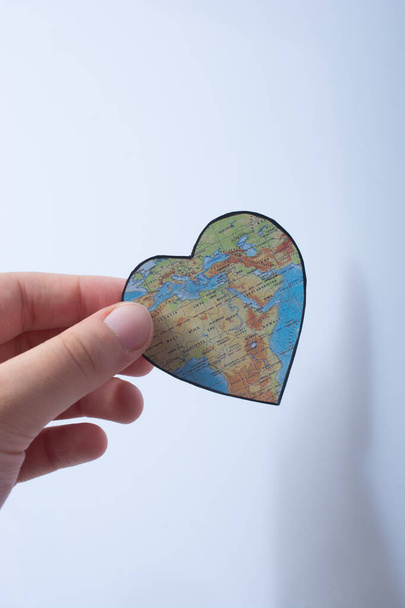 αντικείμενο σε σχήμα καρδιάς με χάρτη της Αφρικής ως έννοια του Αγίου Βαλεντίνου στο χέρι - Φωτογραφία, εικόνα