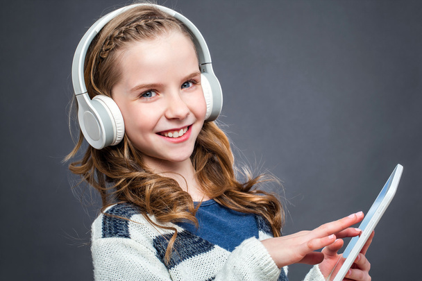 Cute girl with head phones and tablet. - Zdjęcie, obraz