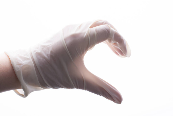 Защитная стерильная перчатка. Перчатка под рукой. Пандемия коронавируса COVID-19
 - Фото, изображение