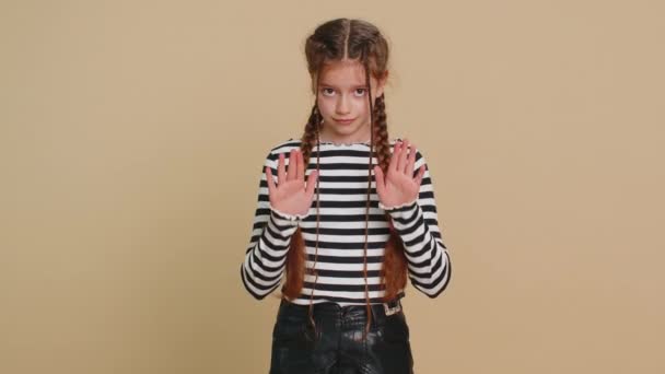 Hé jij, wees voorzichtig. Strikte tiener meisje kind waarschuwing met vermanende handen gebaar te zeggen nee wees voorzichtig schreeuwen en het geven van advies om gevaar teken te voorkomen. tiener kinderen op beige achtergrond - Video