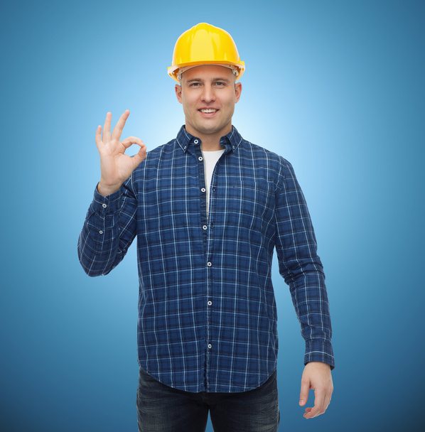 smiling male builder in helmet showing ok sign - Foto, Bild