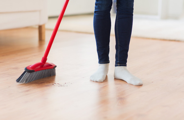 close up of woman legs with broom sweeping floor - Zdjęcie, obraz