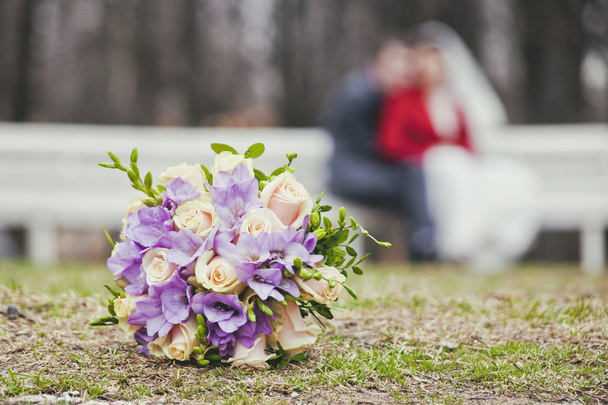 Θολή σιλουέτα νεόνυμφους πίσω από τη γαμήλια ανθοδέσμη - Φωτογραφία, εικόνα