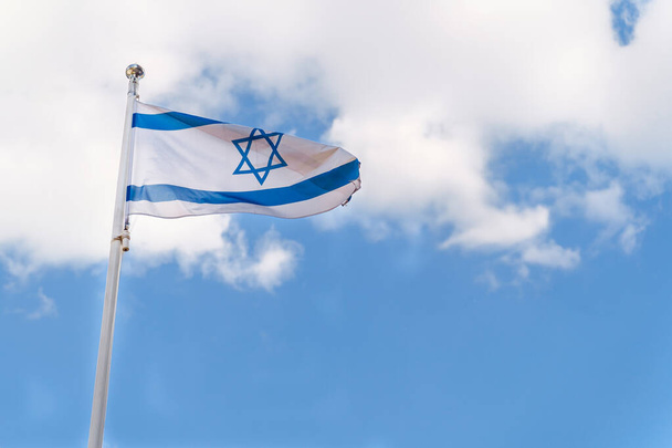 Bandera de Israel Bandera nacional del Estado de Israel sobre fondo azul cielo con nubes blancas. - Foto, Imagen