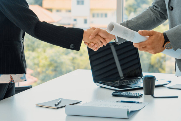 Handschlag zwischen Geschäftsmann und Geschäftsfrau in einem modernen Büro am Arbeitsplatz. Menschen Corporate Business Deals Konzept. uds - Foto, Bild