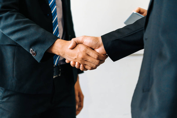 Concept d'accord entre hommes d'affaires. Un homme d'affaires serre la main d'un autre homme d'affaires dans la salle de réunion du bureau. uds - Photo, image
