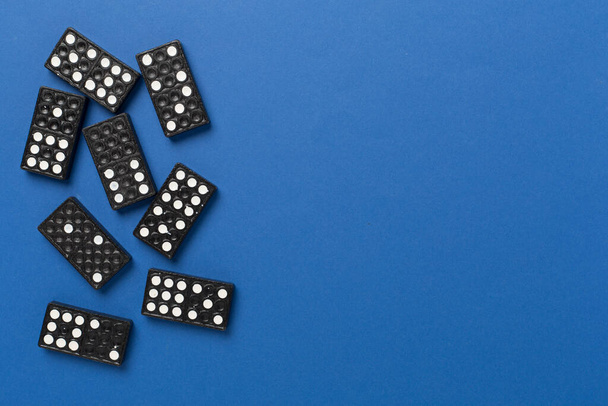 Negro fichas de dominó en el fondo de color, vista superior - Foto, imagen